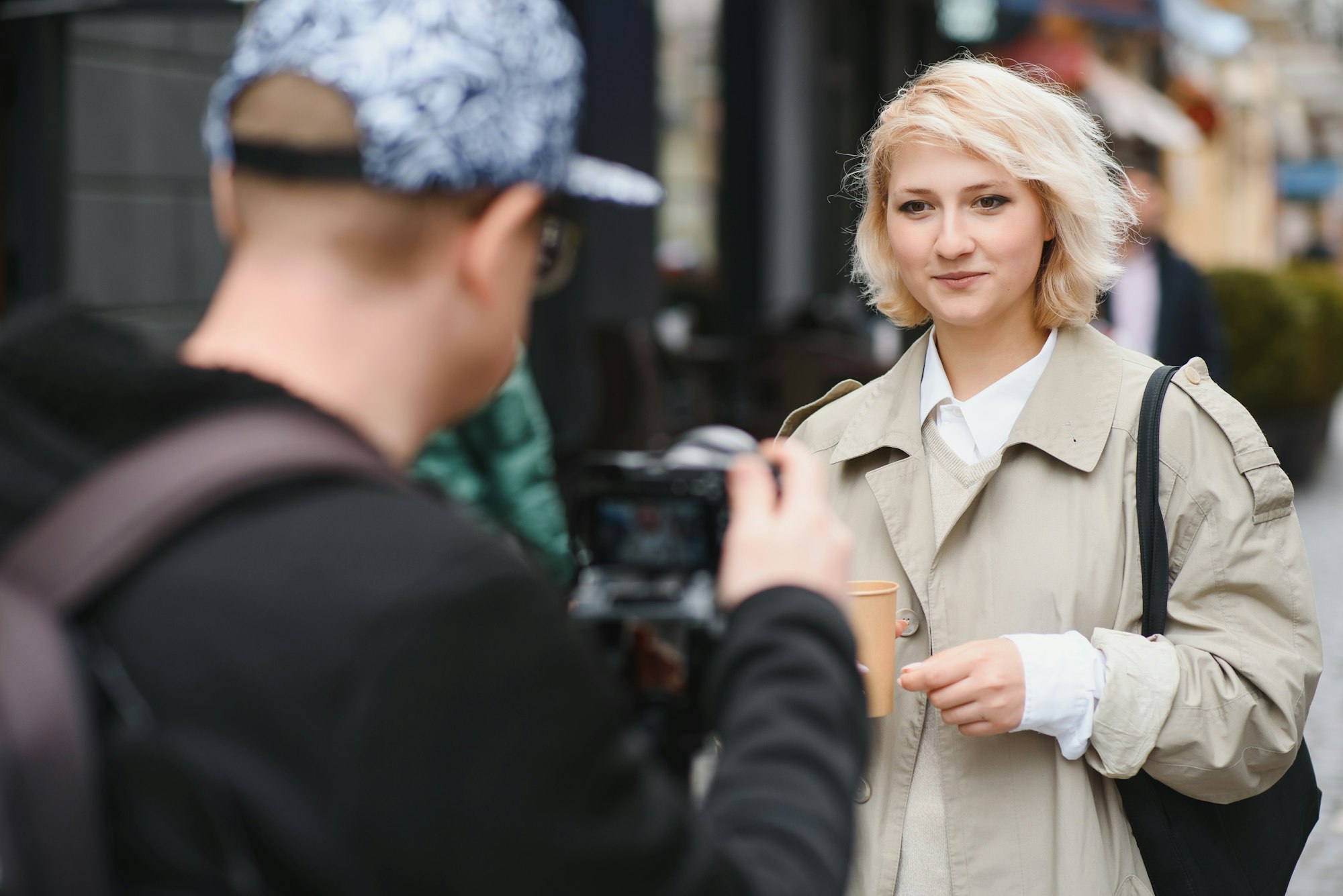 A girl makes a video blog with a cameraman on the street. Young woman blogger