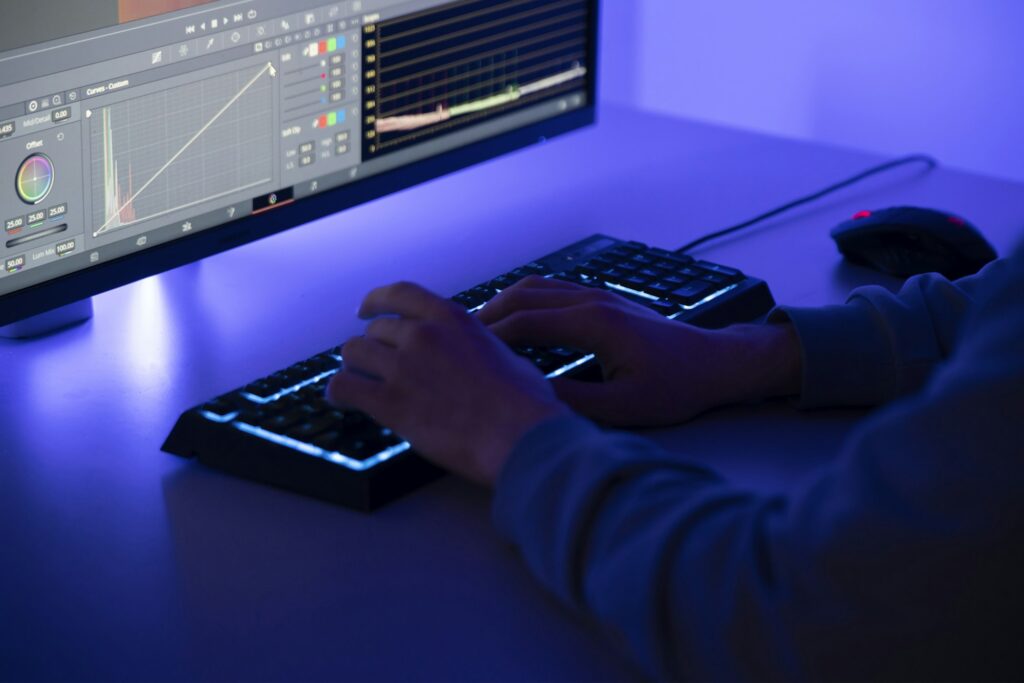 Video Editor Engaged in Post-Production Work on a Computer in a dark Studio